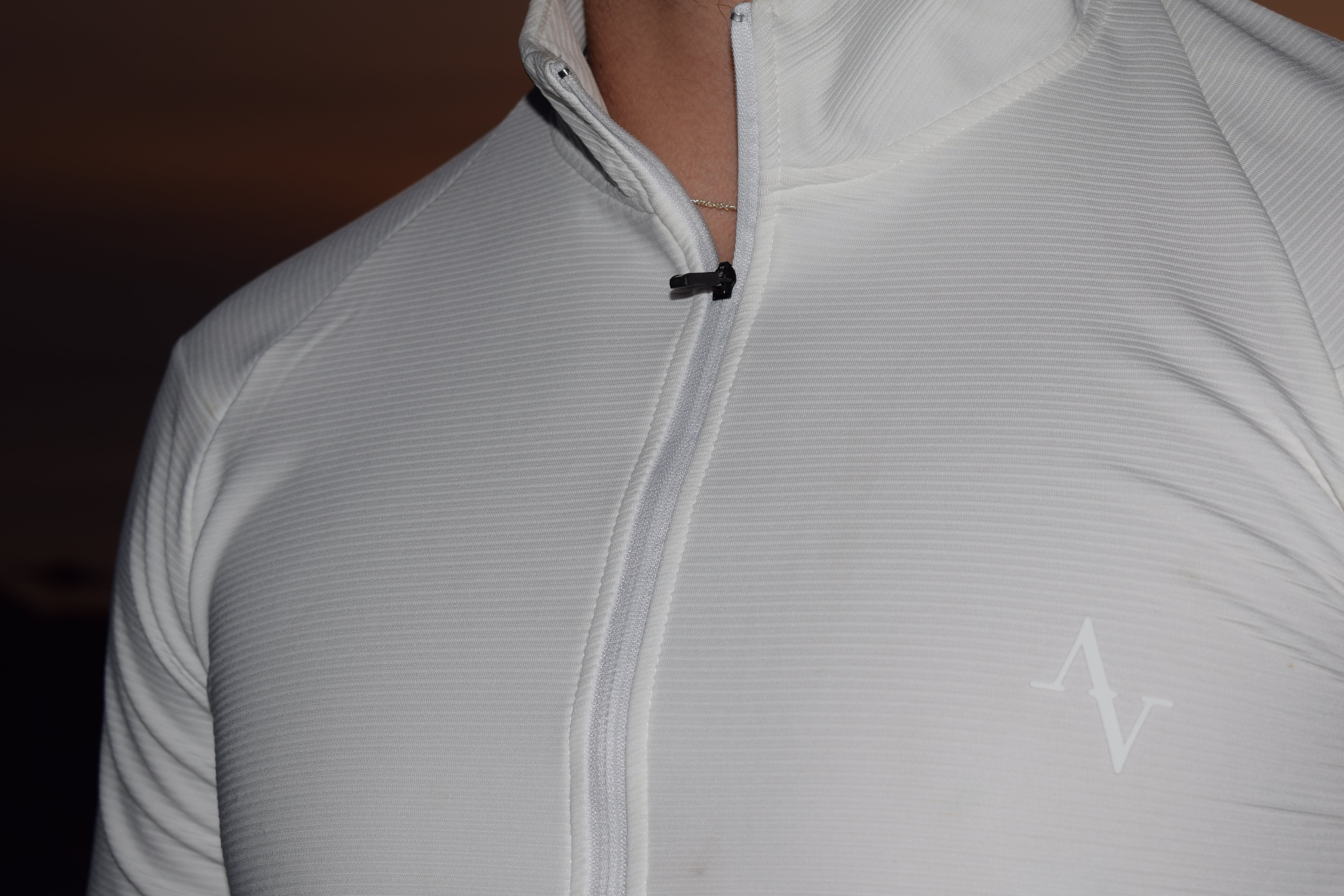 White long sleeve half zip in front of a sunset