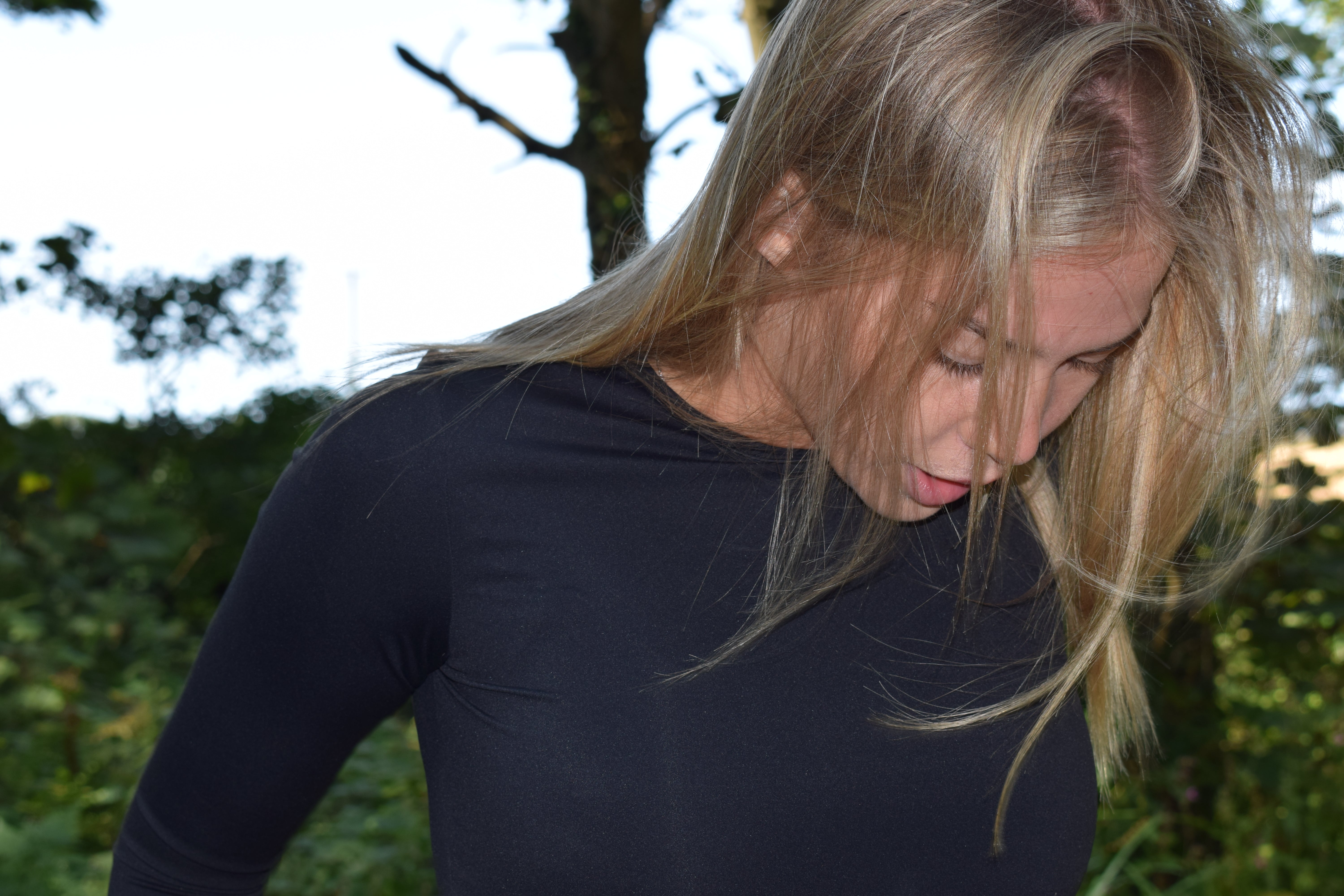 Woman wearing a black long-sleeve shirt outdoors with blurred background