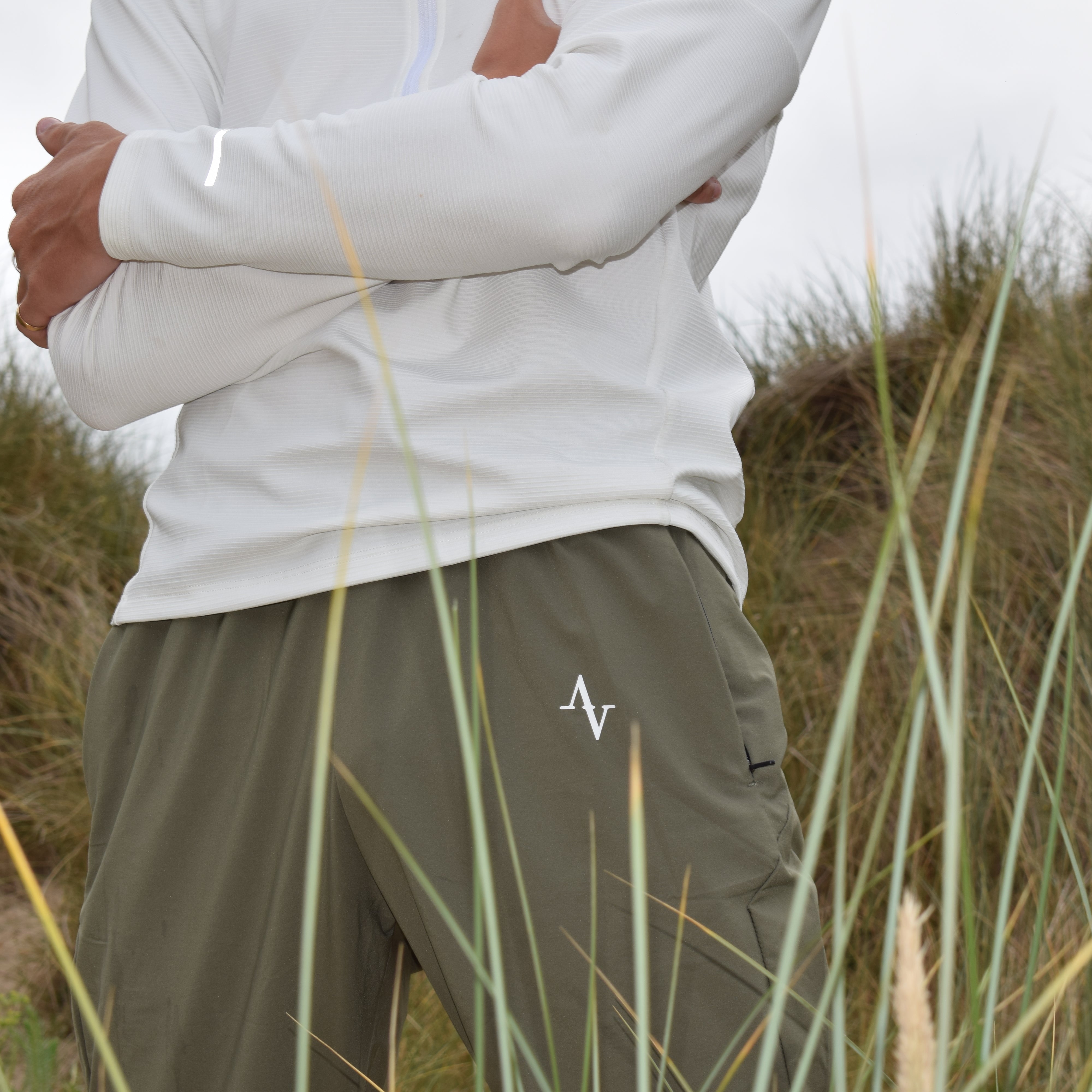 White Naieve khaki straight leg pants in sand dune background