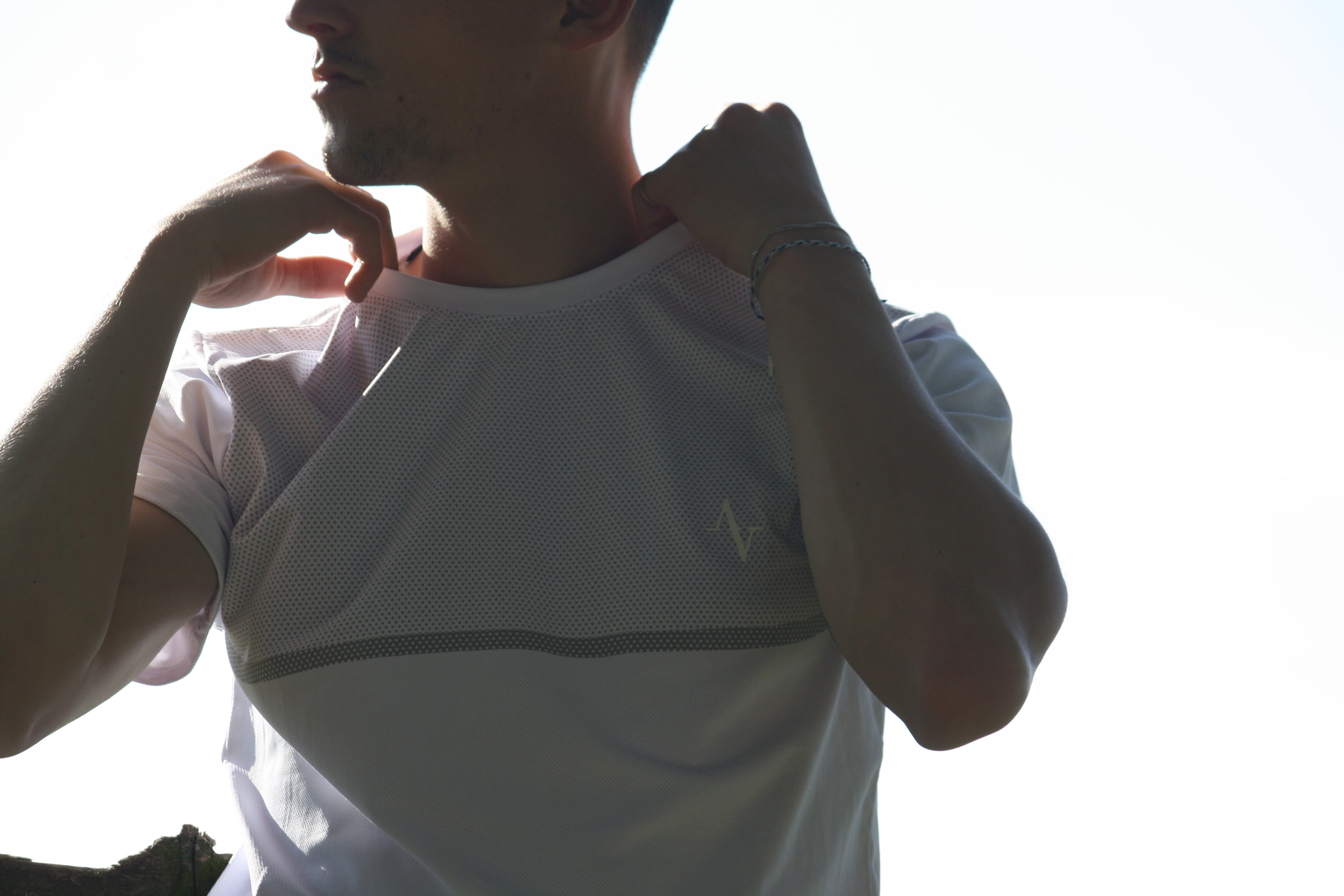 Person wearing a white t-shirt with a logo on a bright background